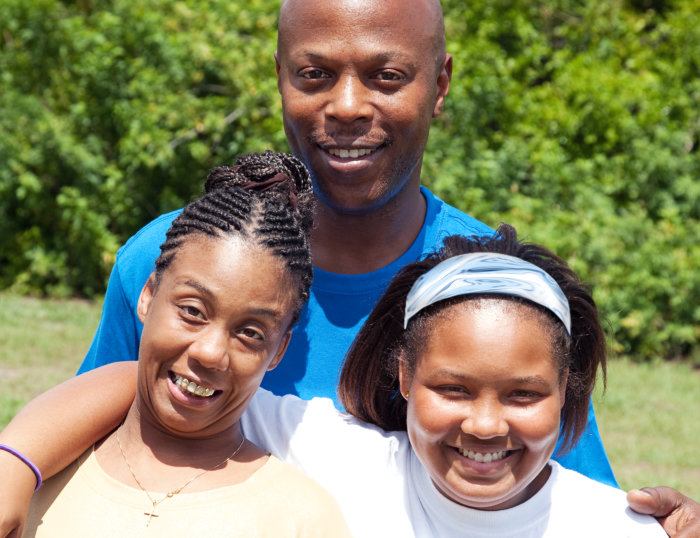 man and two woman smilling