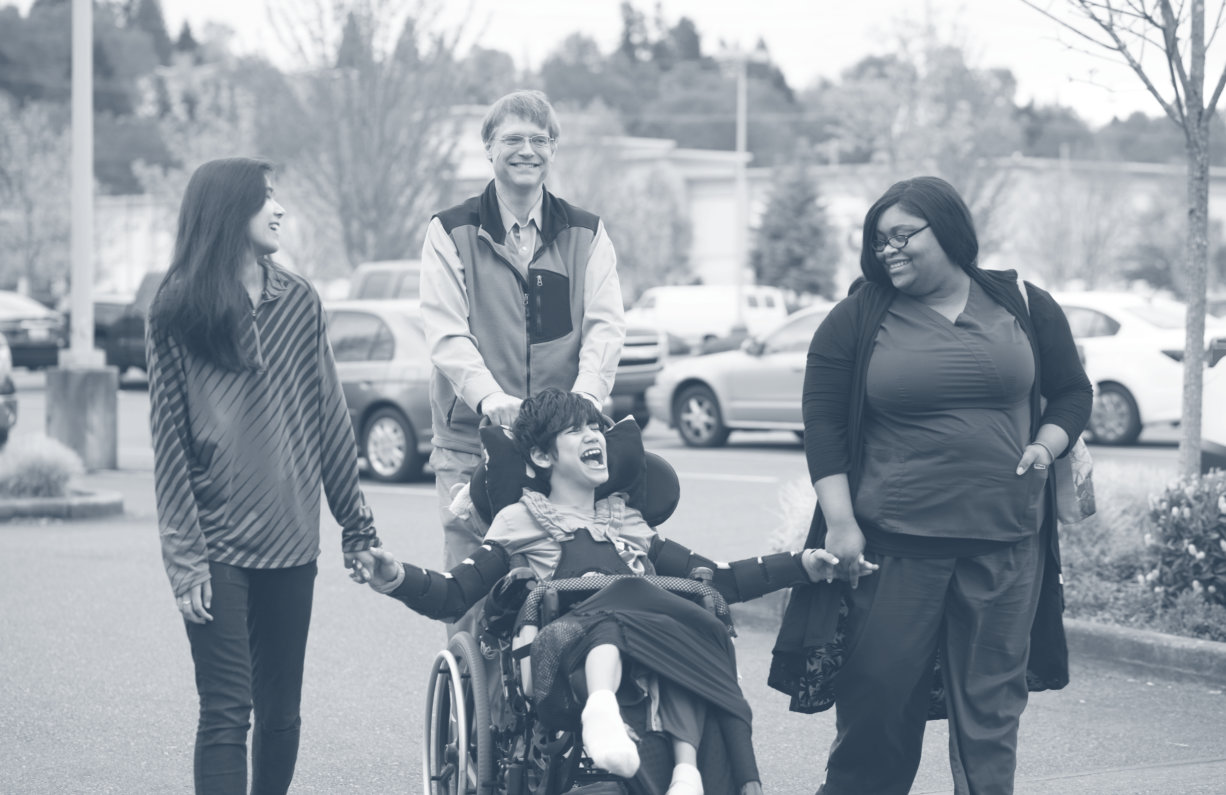three person walking and one person in a wheelchair