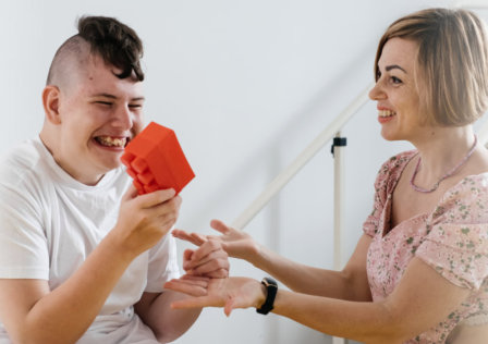 man holding a toy and a smilling woman